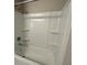 Bathroom featuring a clean, white tub and shower combination with built-in shelving for storage at 1509 Venice Ln, Davenport, FL 33896