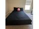 Bright bedroom showcasing a black bed and neutral walls, complemented by natural light from the window at 1509 Venice Ln, Davenport, FL 33896