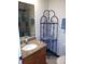 Bathroom sink with granite countertop, wooden cabinets, and decorative corner shelf at 5310 Pebble Beach Dr # F, Orlando, FL 32811