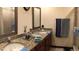 Bathroom featuring double sinks with granite countertops and a decorative framed mirror at 5310 Pebble Beach Dr # F, Orlando, FL 32811