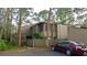 A home with natural-looking trim has a small garden near the entrance and a red car in the driveway at 5310 Pebble Beach Dr # F, Orlando, FL 32811