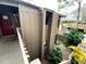 Exterior view of a property with natural looking trim, a red door, and a tropical-looking garden at 5310 Pebble Beach Dr # F, Orlando, FL 32811