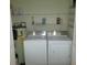 Laundry room equipped with washer, dryer, shelves, and a hot water tank at 5310 Pebble Beach Dr # F, Orlando, FL 32811