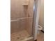 Tiled shower stall with glass door, chrome fixtures, and a built-in shelf at 5310 Pebble Beach Dr # F, Orlando, FL 32811