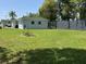 Extensive grassy backyard featuring a dark privacy wall, partially shaded by mature trees at 705 Grandview Ave, Altamonte Springs, FL 32701