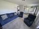Inviting living room featuring a comfortable blue sofa and two recliners on neutral carpeting at 705 Grandview Ave, Altamonte Springs, FL 32701