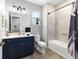 Stylish bathroom featuring navy vanity, wood floors, and shower with tub at 10298 Sw 96Th Loop, Ocala, FL 34481
