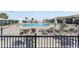 Community pool with multiple lounge chairs, umbrellas, a beautiful building, and a black metal fence at 10298 Sw 96Th Loop, Ocala, FL 34481