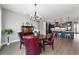 Elegant dining area featuring hardwood floors, sophisticated lighting, and stylish red upholstered chairs at 10298 Sw 96Th Loop, Ocala, FL 34481