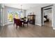 Bright dining room with wood floors, modern lighting, and large windows showcasing an outdoor view at 10298 Sw 96Th Loop, Ocala, FL 34481