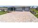 Long patterned brick driveway leading to a well-maintained two-car garage at 10298 Sw 96Th Loop, Ocala, FL 34481