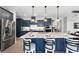 Eat-in kitchen featuring a large island with bar stool seating, stainless steel appliances, and modern lighting at 10298 Sw 96Th Loop, Ocala, FL 34481