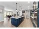 Eat-in kitchen featuring navy cabinetry, stainless steel appliances, and a large island with pendant lighting at 10298 Sw 96Th Loop, Ocala, FL 34481