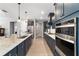 Gourmet kitchen boasts stainless steel appliances, navy cabinetry, and a spacious island with white countertops at 10298 Sw 96Th Loop, Ocala, FL 34481