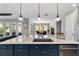 Open kitchen featuring an island with granite countertops, stainless steel sink, and modern lighting fixtures at 10298 Sw 96Th Loop, Ocala, FL 34481