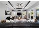 Comfortable living room with a tray ceiling, ceiling fan, large-screen TV, and sliding glass doors at 10298 Sw 96Th Loop, Ocala, FL 34481