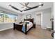 Tranquil main bedroom with tray ceiling, ceiling fan, and a scenic view from the window at 10298 Sw 96Th Loop, Ocala, FL 34481