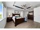 Comfortable main bedroom with a tray ceiling, ceiling fan, and a suite of wooden furniture at 10298 Sw 96Th Loop, Ocala, FL 34481