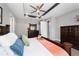 Relaxing main bedroom featuring a tray ceiling, ceiling fan, and a stylish set of wooden bedroom furniture at 10298 Sw 96Th Loop, Ocala, FL 34481