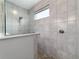 Contemporary shower with stone-look tile, pebble floor, and glass enclosure at 10298 Sw 96Th Loop, Ocala, FL 34481