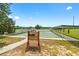 Outdoor shuffleboard courts shaded by a green canopy, with benches and manicured landscaping at 10298 Sw 96Th Loop, Ocala, FL 34481