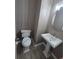 Small bathroom with tile flooring, pedestal sink, toilet, and a round mirror at 1521 Sourwood Dr, Ocoee, FL 34761