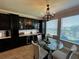 Breakfast nook with modern chandelier, built-in bar, and large windows with backyard views at 1521 Sourwood Dr, Ocoee, FL 34761