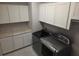 Laundry room with updated appliances, granite countertop, and white cabinets at 1521 Sourwood Dr, Ocoee, FL 34761