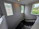 Bright stairway with black iron railing, carpeted steps and multiple windows that provide great natural light at 1521 Sourwood Dr, Ocoee, FL 34761