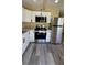 Stylish kitchen featuring stainless steel appliances, white cabinets, and wood-look flooring at 1923 Beechwood Dr, Lakeland, FL 33803