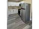 Modern kitchen with white cabinets, stainless steel appliances, and gray wood-look floors at 1923 Beechwood Dr, Lakeland, FL 33803