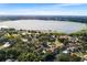 An aerial view showcases a picturesque lake surrounded by lush trees and well-maintained homes in a desirable neighborhood at 2110 Reaney Rd, Lakeland, FL 33803