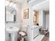 Bathroom with patterned wallpaper, pedestal sink and connected vanity area at 2110 Reaney Rd, Lakeland, FL 33803