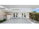 Covered entryway featuring white columns, French doors, and seating provides an elegant welcome at 2110 Reaney Rd, Lakeland, FL 33803