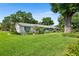 A single story home has a manicured front lawn with mature landscaping at 2110 Reaney Rd, Lakeland, FL 33803