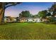 Lovely home with a sprawling front lawn, mature trees, and well-maintained landscaping, illuminated at dusk at 2110 Reaney Rd, Lakeland, FL 33803