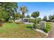 Beautiful front yard with lush green lawn, mature palm tree and modern white carport at 2110 Reaney Rd, Lakeland, FL 33803