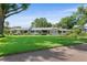 Charming single-story home with a well-manicured lawn, mature trees, and classic architectural details at 2110 Reaney Rd, Lakeland, FL 33803
