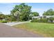 Beautifully landscaped front yard with lush green lawn and mature trees create inviting curb appeal at 2110 Reaney Rd, Lakeland, FL 33803