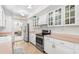 Charming kitchen features white cabinetry, stainless steel appliances, and a lovely view into the living area at 2110 Reaney Rd, Lakeland, FL 33803
