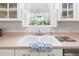 Bright kitchen featuring a white double basin sink with garden view and white shuttered window at 2110 Reaney Rd, Lakeland, FL 33803
