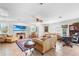 Spacious living area with tile floors, ample seating, a ceiling fan, and view of beach on the TV at 2110 Reaney Rd, Lakeland, FL 33803