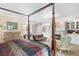 Bright main bedroom with a four-poster bed, a fireplace, and a cozy sitting area at 2110 Reaney Rd, Lakeland, FL 33803