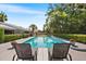 Inviting pool with patio chairs, surrounded by lush greenery, offering a peaceful outdoor retreat at 2110 Reaney Rd, Lakeland, FL 33803