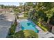 Aerial view of a sparkling pool surrounded by lush greenery and tropical plants in backyard at 2110 Reaney Rd, Lakeland, FL 33803