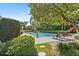 Secluded pool area featuring a large tree, lush landscaping, lounge chairs, and stone pavers at 2110 Reaney Rd, Lakeland, FL 33803