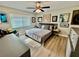 Inviting bedroom with wood floors, a large window with blinds, a ceiling fan, and neutral decor at 4128 Palo Alto Dr, Lakeland, FL 33813