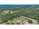 Aerial view showcasing a home with outbuildings surrounded by lush greenery and scattered residences in the distance at 21551 Lake Seneca Rd, Eustis, FL 32736