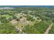 An aerial shot of a rural neighborhood with a well-maintained home surrounded by lush trees and green spaces at 21551 Lake Seneca Rd, Eustis, FL 32736