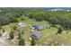 A scenic aerial view of a house nestled among lush trees, with a separate building and a garden, creating a serene landscape at 21551 Lake Seneca Rd, Eustis, FL 32736